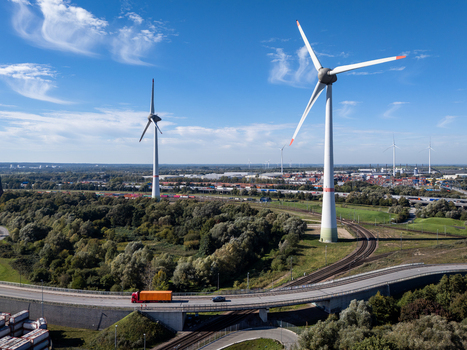 Aerial view of Altenwerder Hauptdeich with wind turbines a truck driving on the highway and surrounding greenery in Hamburg Germany. Aerial view of Altenwerder Hauptdeich with wind turbines a truck driving on the highway and surrounding greenery in Hamburg Germany.