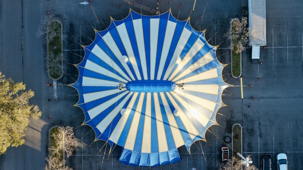 Aerial view of a striking blue and white striped circus tent standing boldly in a stark parking lot St. Augustine Florida United States. Aerial view of a striking blue and white striped circus tent standing boldly in a stark parking lot St. Augustine Florida United States.