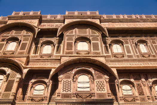 View of the intricate sandstone carvings and arched windows of the historic Mehrangarh Fort in Jodhpur Rajasthan India. View of the intricate sandstone carvings and arched windows of the historic Mehrangarh Fort in Jodhpur Rajasthan India.