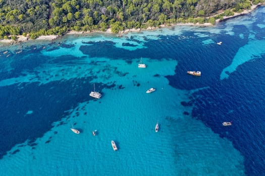 Aerial view of Ile Sainte Marguerite with turquoise waters and anchored boats off the coast of Cannes Provence Alpes Cote d Azur France. Aerial view of Ile Sainte Marguerite with turquoise waters and anchored boats off the coast of Cannes Provence Alpes Cote d Azur France.