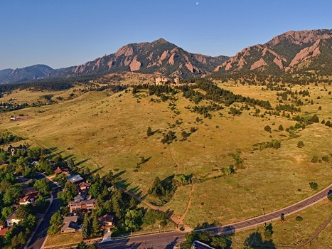 Aerial view of NCAR and UCAR Foothills Laboratory situated on a grassy hillside with the Flatirons mountain range in the background in Boulder Colorado United States.