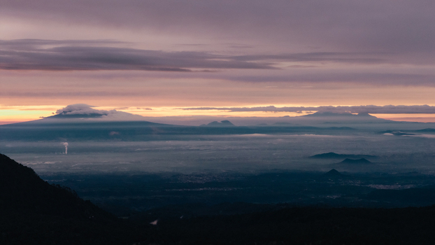 Aerial view of Parque Nacional Iztaccihuatl Popocatepetl featuring volcanic peaks under a dramatic sunset sky with misty valleys in Amecameca de Juarez Estado de Mexico Mexico.