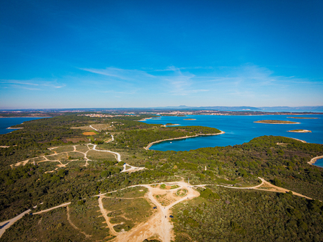 Aerial view of the verdant coastline meeting the turquoise Adriatic Sea with scattered islands dotting the horizon Pula Istria County Croatia.