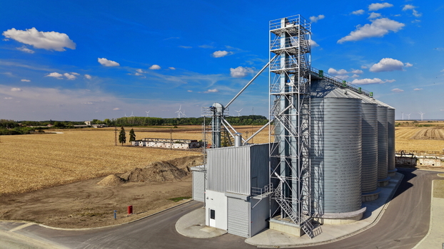 Aerial view of the storage silo surrounded by agricultural fields and wind turbines in Bavaniste Vojvodina Serbia.
