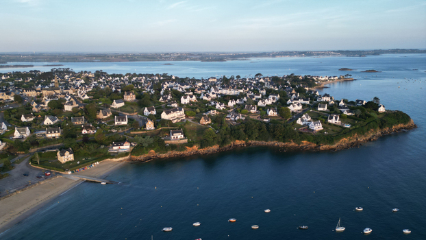 Aerial view of the charming coastal town where white houses meet the blue sea contrasted by sandy shores and verdant headlands Carantec Bretagne France. Aerial view of the charming coastal town where white houses meet the blue sea contrasted by sandy shores and verdant headlands Carantec Bretagne France.