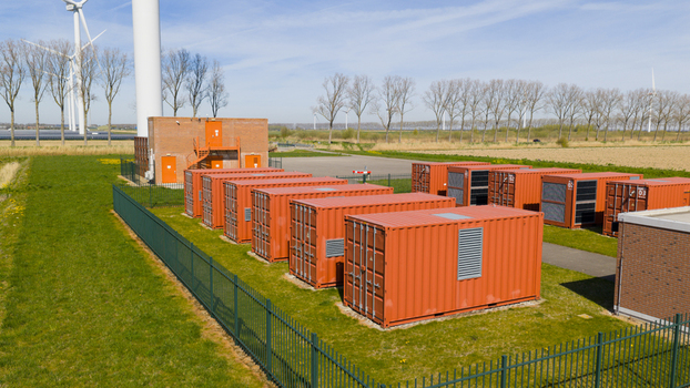Aerial view of battery storage system at wind park with wind turbines
