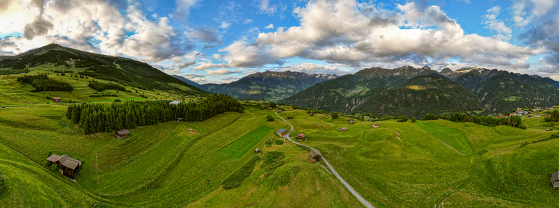 Aerial view of the lush green alpine meadows and traditional wooden farmhouses in the mountainous landscape of Prutz Tyrol Austria. Aerial view of the lush green alpine meadows and traditional wooden farmhouses in the mountainous landscape of Prutz Tyrol Austria.