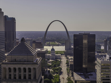 Aerial view of The Gateway Arch rising above the Old Courthouse and the Mississippi River surrounded by urban skyscrapers in St. Louis Missouri United States.