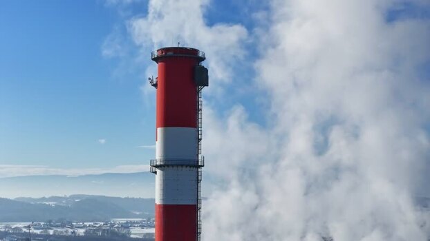 Aerial view of an industrial chimney with white smoke in Austria.