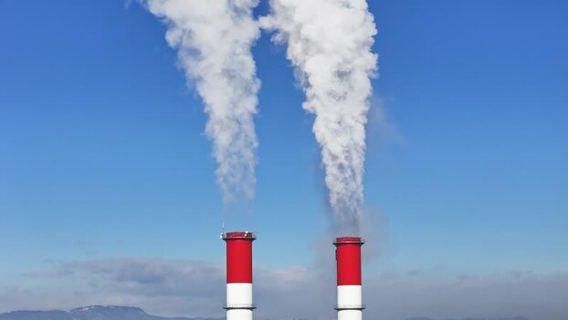 Aerial view of industrial chimneys emitting white smoke Austria.