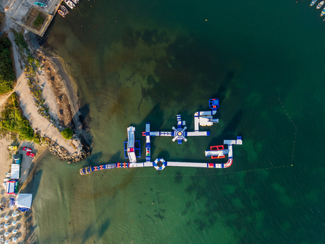 Aerial view of an inflatable water park floating in the clear turquoise waters of a bay near the sandy beach in Kiten Burgas Bulgaria. Aerial view of an inflatable water park floating in the clear turquoise waters of a bay near the sandy beach in Kiten Burgas Bulgaria.