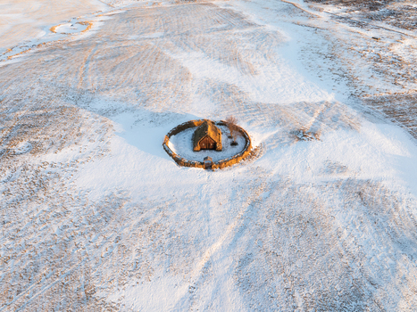 Aerial view of the historic turf church Grafarkirkja surrounded by a circular stone wall in a snow covered landscape in Hofsos Skagafjordur Iceland. Aerial view of the historic turf church Grafarkirkja surrounded by a circular stone wall in a snow covered landscape in Hofsos Skagafjordur Iceland.