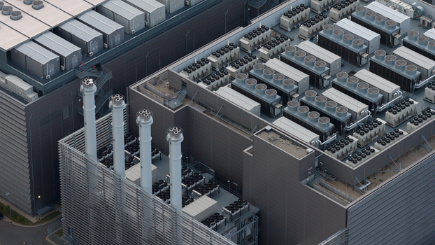 Aerial view of the Equinix Data Center featuring rows of industrial cooling units and tall exhaust stacks on the rooftop in Frankfurt am Main Hessen Germany.