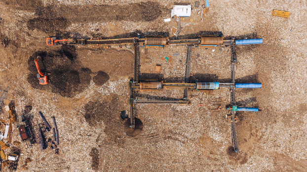 Aerial view of a waste sorting facility with industrial machinery conveyor belts and excavators operating on a large landfill site in Chennai India. Aerial view of a waste sorting facility with industrial machinery conveyor belts and excavators operating on a large landfill site in Chennai India.