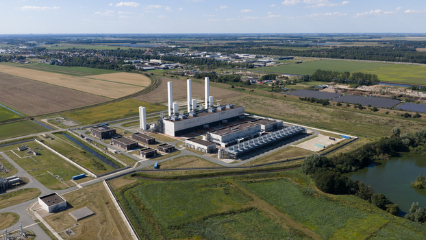 Aerial view of the Gasunie and Air Products nitrogen factory with tall chimneys and industrial buildings surrounded by agricultural fields and a pond in Muntendam Groningen Netherlands.