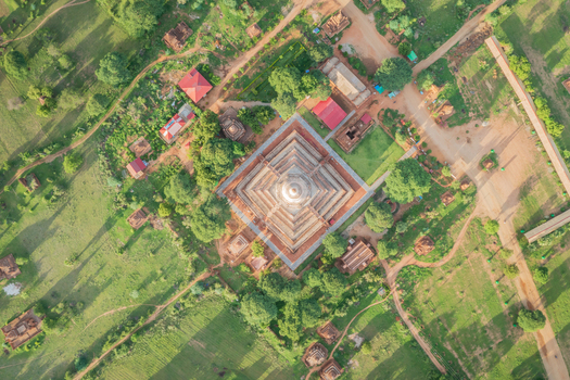 Aerial view of the ancient pagoda with its tiered square base surrounded by lush greenery and smaller temples in Old Bagan Mandalay Region Myanmar Burma. Aerial view of the ancient pagoda with its tiered square base surrounded by lush greenery and smaller temples in Old Bagan Mandalay Region Myanmar Burma.