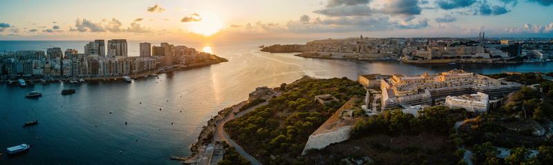 Aerial view of the historic fortifications of Fort Manoel and the Valletta skyline during a golden sunset over Marsamxett Harbour in Valletta Malta.