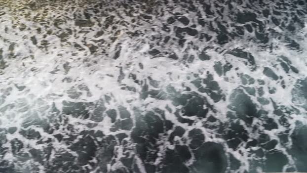 View of foamy sea water and churning waves in the Aegean Sea Greece.