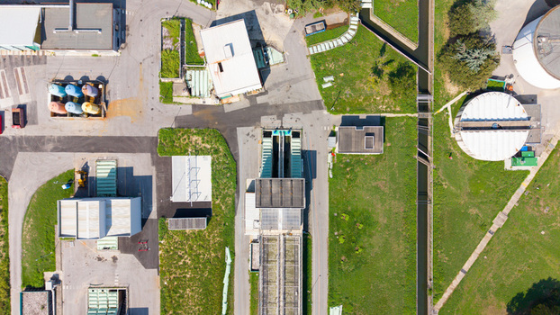 Aerial view of a water treatment plant featuring industrial tanks concrete infrastructure and surrounding green spaces in Milan Lombardy Italy. Aerial view of a water treatment plant featuring industrial tanks concrete infrastructure and surrounding green spaces in Milan Lombardy Italy.