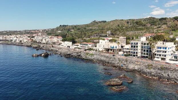 Aerial view of the rocky coastline and town of Aci Castello Italy.