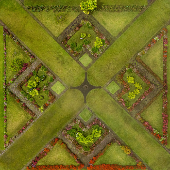Aerial view of the symmetrical geometric patterns of a formal garden with vibrant flower beds and manicured green lawns in Cinchona Alajuela Province Costa Rica. Aerial view of the symmetrical geometric patterns of a formal garden with vibrant flower beds and manicured green lawns in Cinchona Alajuela Province Costa Rica.