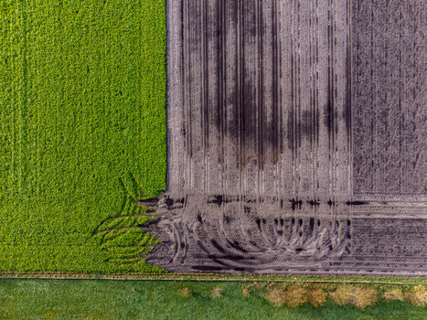 Aerial view of verdant fields juxtapose with dark tilled earth tire tracks carving patterns across the landscape Hunebed D52 Diever Drenthe Netherlands. Aerial view of verdant fields juxtapose with dark tilled earth tire tracks carving patterns across the landscape Hunebed D52 Diever Drenthe Netherlands.