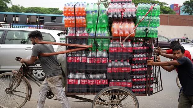 View of men pulling a cart loaded with soda bottles Bangladesh.