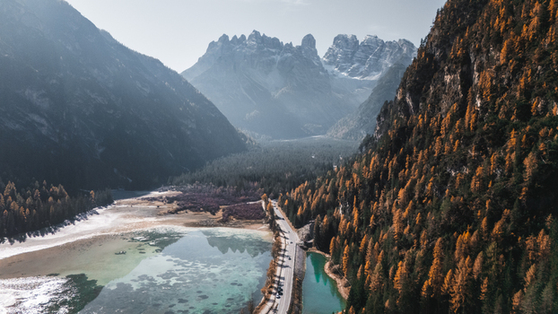 Aerial view of Durrensee lake with turquoise water surrounded by autumn forests and the jagged peaks of the Dolomites in Toblach Trentino Alto Adige S Italy. Aerial view of Durrensee lake with turquoise water surrounded by autumn forests and the jagged peaks of the Dolomites in Toblach Trentino Alto Adige S Italy.