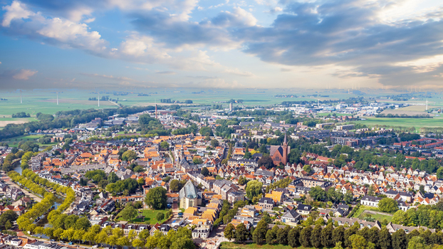 Aerial view of the historic town of Bolsward featuring the City Hall traditional Dutch rooftops winding canals and lush green surroundings in Bolsward Friesland Netherlands. Aerial view of the historic town of Bolsward featuring the City Hall traditional Dutch rooftops winding canals and lush green surroundings in Bolsward Friesland Netherlands.