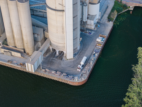 Aerial view of the Zementwerk Berlin concrete plant with tall silos industrial equipment and a truck parked near the canal in Berlin Berlin Germany. Aerial view of the Zementwerk Berlin concrete plant with tall silos industrial equipment and a truck parked near the canal in Berlin Berlin Germany.