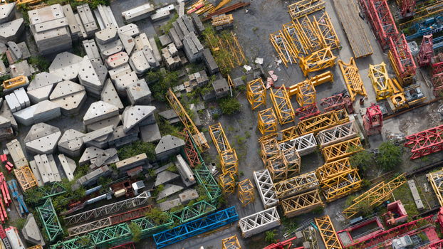Aerial view of Feluy de Parc Industriel featuring stacks of concrete blocks and yellow and red crane lattice sections in an industrial storage yard in Seneffe Region wallonne Belgium.