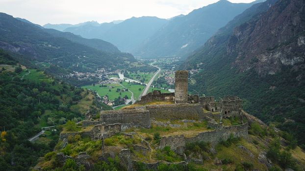 Aerial view of the medieval Saint Germain Castle ruins overlooking the green Aosta Valley with a river and mountains in Montjovet Aosta Valley Italy.