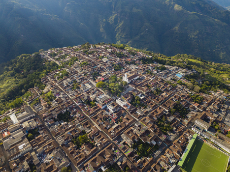 Aerial view of terracotta rooftops sprawling across the landscape punctuated by a central church nestled amidst verdant hills Salamina Caldas Colombia. Aerial view of terracotta rooftops sprawling across the landscape punctuated by a central church nestled amidst verdant hills Salamina Caldas Colombia.