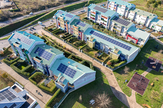 Aerial view of modern residential buildings featuring solar panels on green roofs private gardens and a playground in Grugliasco Piedmont Italy. Aerial view of modern residential buildings featuring solar panels on green roofs private gardens and a playground in Grugliasco Piedmont Italy.
