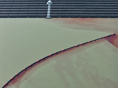 Aerial view of floating solar farm panels on a lake with a containment boom separating water sections in Dulmen North Rhine Westphalia Germany. Aerial view of floating solar farm panels on a lake with a containment boom separating water sections in Dulmen North Rhine Westphalia Germany.