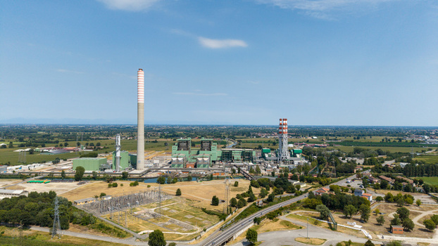 Aerial view of the TTEP Tavazzano thermal power plant and TERNA electrical substation featuring industrial chimneys and cooling towers in Tavazzano con Villavesco Lombardy Italy.