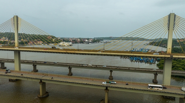 Aerial view of Atal Setu bridge spanning the Mandovi River with traffic and boats below in Panaji Goa India.