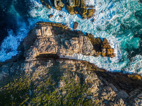 Aerial view of rugged granite cliffs and crashing turquoise waves at Torndirrup National Park in Torndirrup Western Australia Australia. Aerial view of rugged granite cliffs and crashing turquoise waves at Torndirrup National Park in Torndirrup Western Australia Australia.