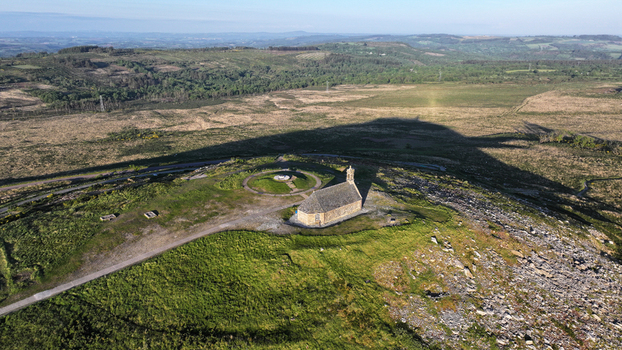 Aerial view of Chapelle Saint Michel de Brasparts on a grassy hilltop overlooking the rugged moorland of the Monts d Arree in Saint Rivoal Bretagne France. Aerial view of Chapelle Saint Michel de Brasparts on a grassy hilltop overlooking the rugged moorland of the Monts d Arree in Saint Rivoal Bretagne France.