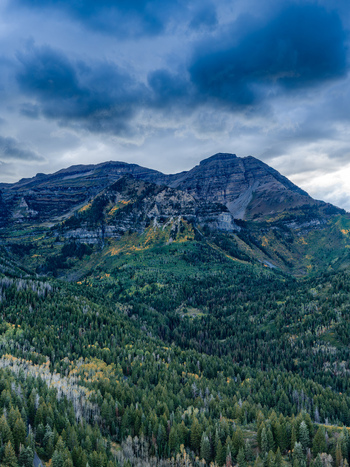 Aerial view of the Alpine Loop Scenic Byway during autumn featuring vibrant fall foliage on mountain slopes dense evergreen forests and rocky peaks in Utah County Utah United States. Aerial view of the Alpine Loop Scenic Byway during autumn featuring vibrant fall foliage on mountain slopes dense evergreen forests and rocky peaks in Utah County Utah United States.