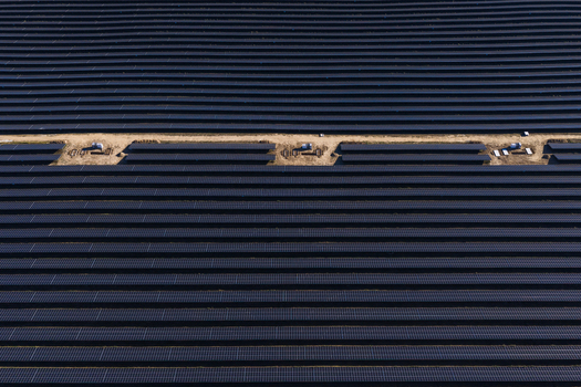 Aerial view of a large scale solar farm with rows of photovoltaic panels and maintenance paths in Uckermark Brandenburg Germany.