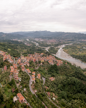 Aerial view of the historic village of Vezzano Ligure with its terracotta rooftops winding roads and lush green hills overlooking the river valley in Vezzano Ligure Liguria Italy.