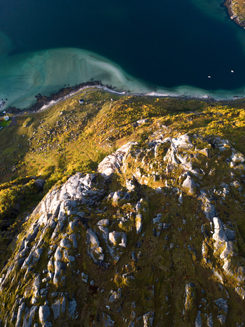 Aerial view of a rugged rocky mountain peak overlooking the turquoise waters and sandy coastline of Tangstad in Leknes Nordland Norway. Aerial view of a rugged rocky mountain peak overlooking the turquoise waters and sandy coastline of Tangstad in Leknes Nordland Norway.