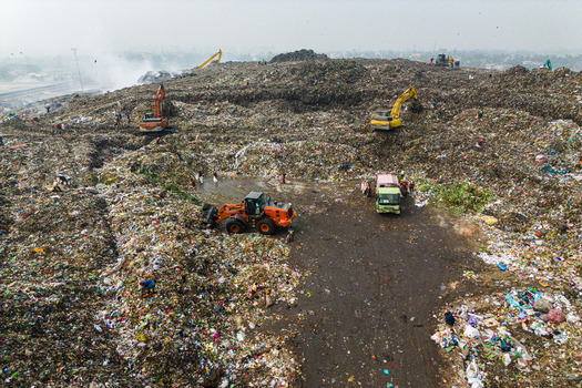 Aminbazar Bangladesh 26 January 2025 Aerial view of the Aminbazar landfill site with excavators and workers moving through vast piles of waste under a hazy sky. Aminbazar Bangladesh 26 January 2025 Aerial view of the Aminbazar landfill site with excavators and workers moving through vast piles of waste under a hazy sky.