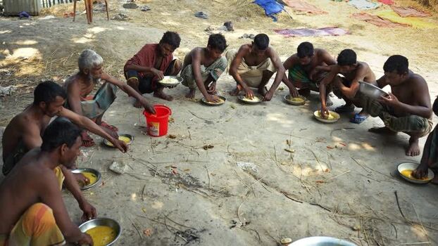 View of men sitting in a circle eating together in Natore Bangladesh. View of men sitting in a circle eating together in Natore Bangladesh.