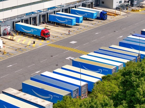 Torrazza Piemonte Italy 03 May 2026 Aerial view of Amazon TRN1 fulfillment center with blue Prime trailers parked at loading docks and a worker walking across the asphalt under bright sunlight. Torrazza Piemonte Italy 03 May 2026 Aerial view of Amazon TRN1 fulfillment center with blue Prime trailers parked at loading docks and a worker walking across the asphalt under bright sunlight.