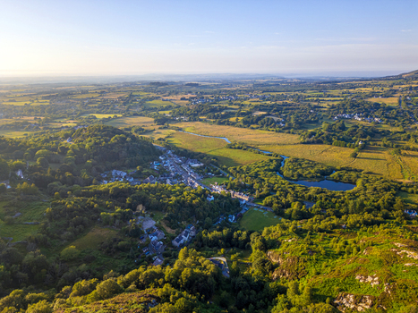 Aerial view of Cwm y glo village nestled in the lush green hills with a small lake and golden hour sunlight illuminating the rural landscape Cwm y glo Wales United Kingdom. Aerial view of Cwm y glo village nestled in the lush green hills with a small lake and golden hour sunlight illuminating the rural landscape Cwm y glo Wales United Kingdom.