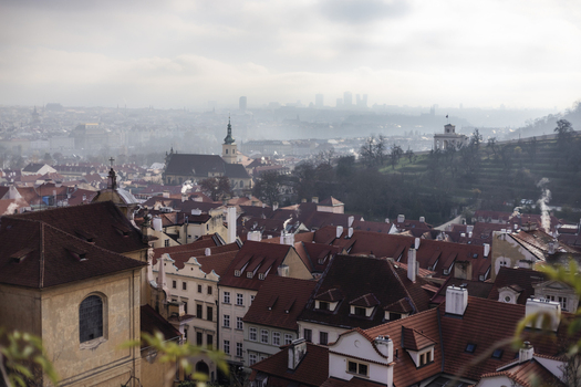 View of red tiled rooftops and historic church spires under a misty sky Prague Prague Czechia. View of red tiled rooftops and historic church spires under a misty sky Prague Prague Czechia.