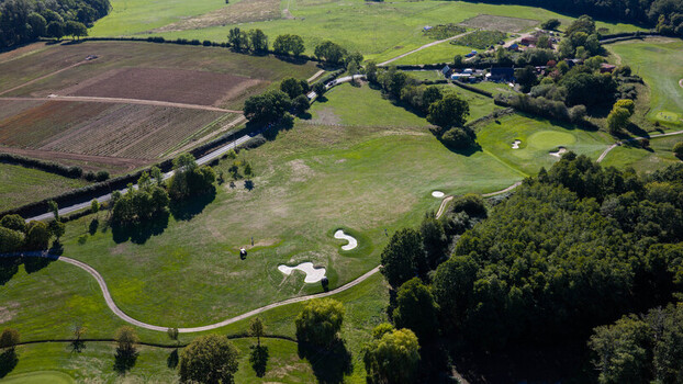 Aerial view of Hamptworth Golf course featuring lush green fairways sand bunkers and surrounding woodland under a clear sky in Hamptworth England United Kingdom. Aerial view of Hamptworth Golf course featuring lush green fairways sand bunkers and surrounding woodland under a clear sky in Hamptworth England United Kingdom.