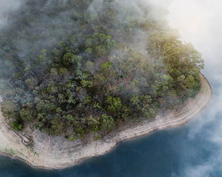 Aerial view of Kangaroo Creek Reservoir with dense eucalyptus forest shrouded in morning mist and calm blue water Adelaide Hills Council South Australia Australia. Aerial view of Kangaroo Creek Reservoir with dense eucalyptus forest shrouded in morning mist and calm blue water Adelaide Hills Council South Australia Australia.
